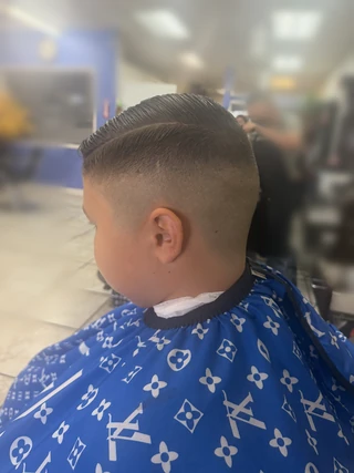 Boy’s side-part haircut with a close fade, viewed from the side.