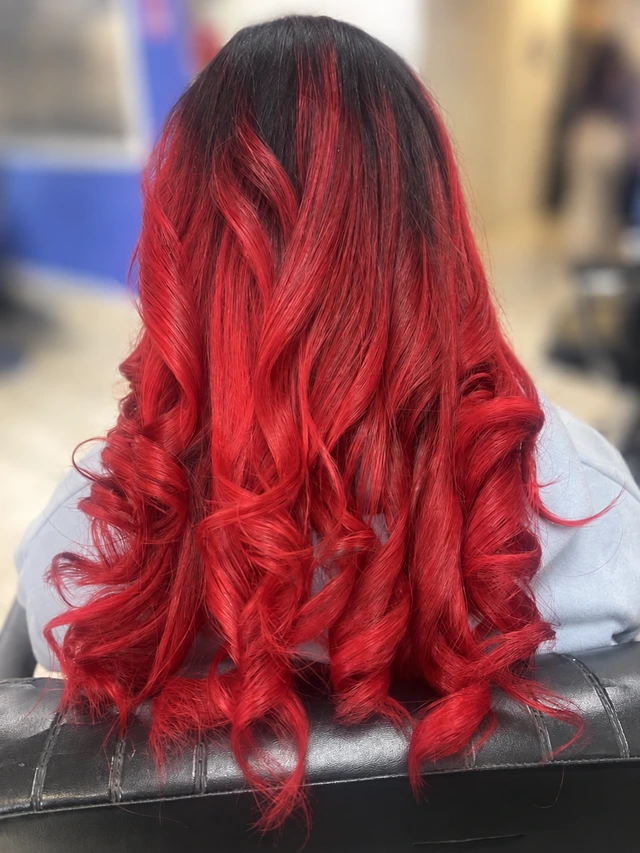 Vibrant red curls with dark roots viewed from behind